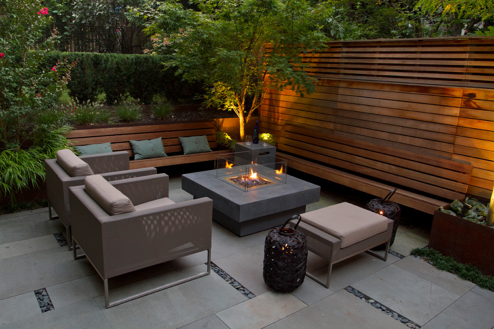 A warmly lit Brooklyn garden with custom seating and fire pit